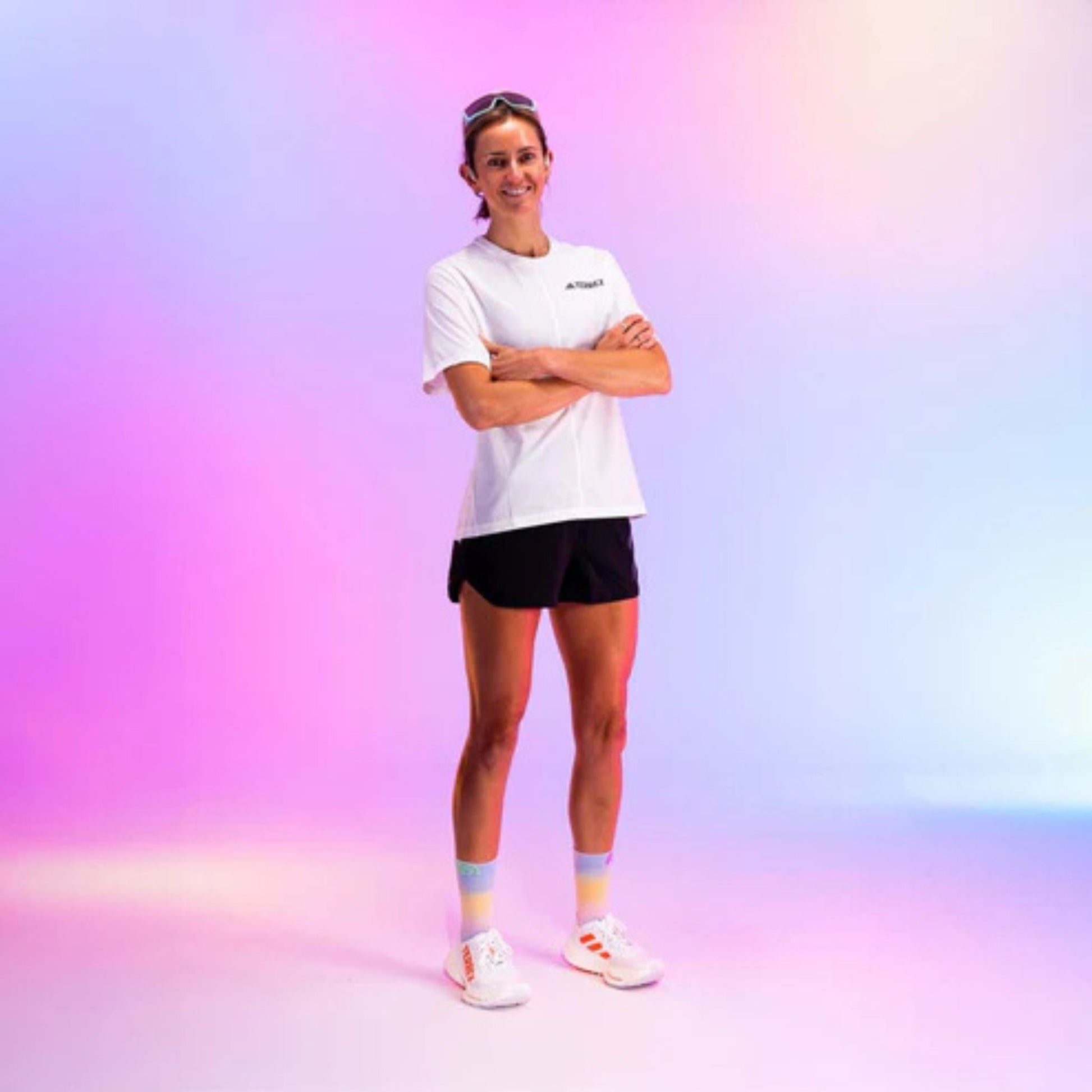 Person wearing a white t-shirt and black shorts on a gradient background