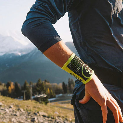 Person wearing a wristband with a mountainous landscape in the background