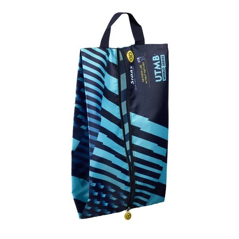A UTMB zippered shoe bag with a geometric pattern in navy blue, black, and light blue, featuring dual top handles and a gold zipper pull.